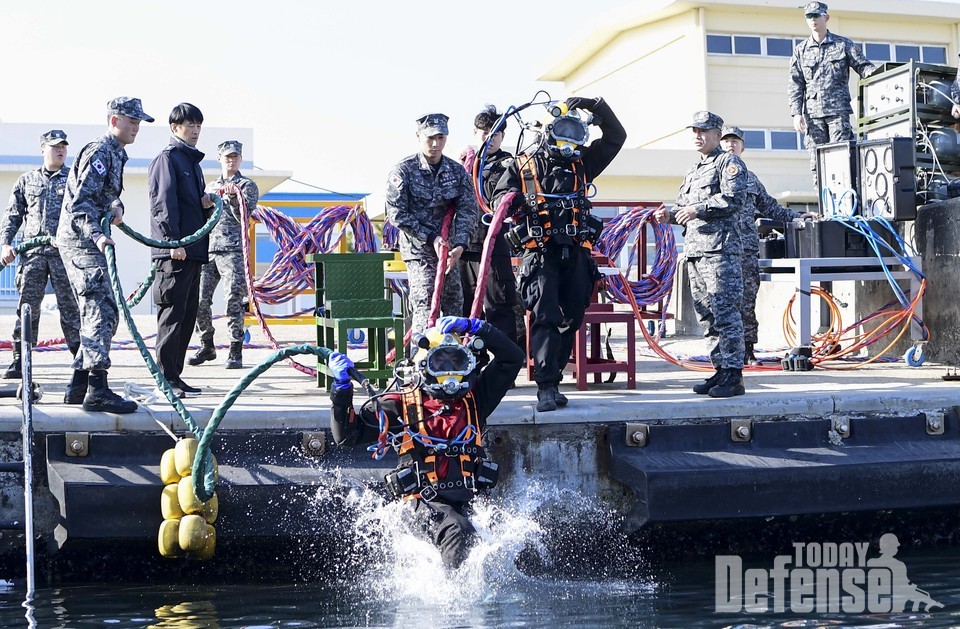 14일 동해 군항에서 진행된 해군 1함대 합동 잠수훈련에서 표면공급 잠수체계(SSDS) 장비를 착용한 1함대 구조작전중대 장병(오른쪽)과 동해해경청 해양특수구조대 대원(왼쪽)이 바다에 뛰어들고 있다.  (사진: 해군1함대)