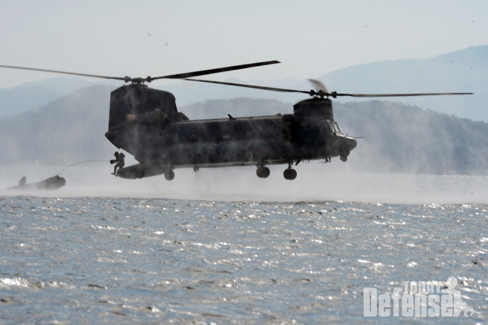 해군특수전전단 해난구조전대(SSU) 구조대원들이 진해 군항 인근 해상에서 저고도 기동중인 HH-47 헬기에서 고무보트와 함께 뛰어내리고 있다.(사진:해군)