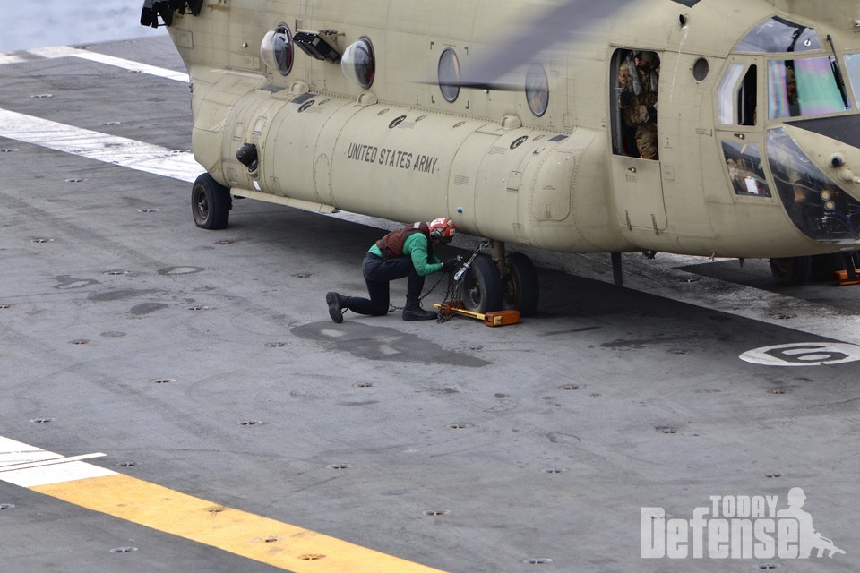 착함한 CH-47F 치누크 헬기를 신속하게 갑판에 고정하고 있다. (사진:U.S.NAVY)