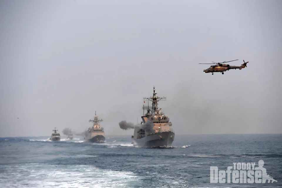 을지문덕함이 127mm함포사격을 하는 동안 링스 해상작전헬기가 대잠작전을 하고 있다.(사진:해군)