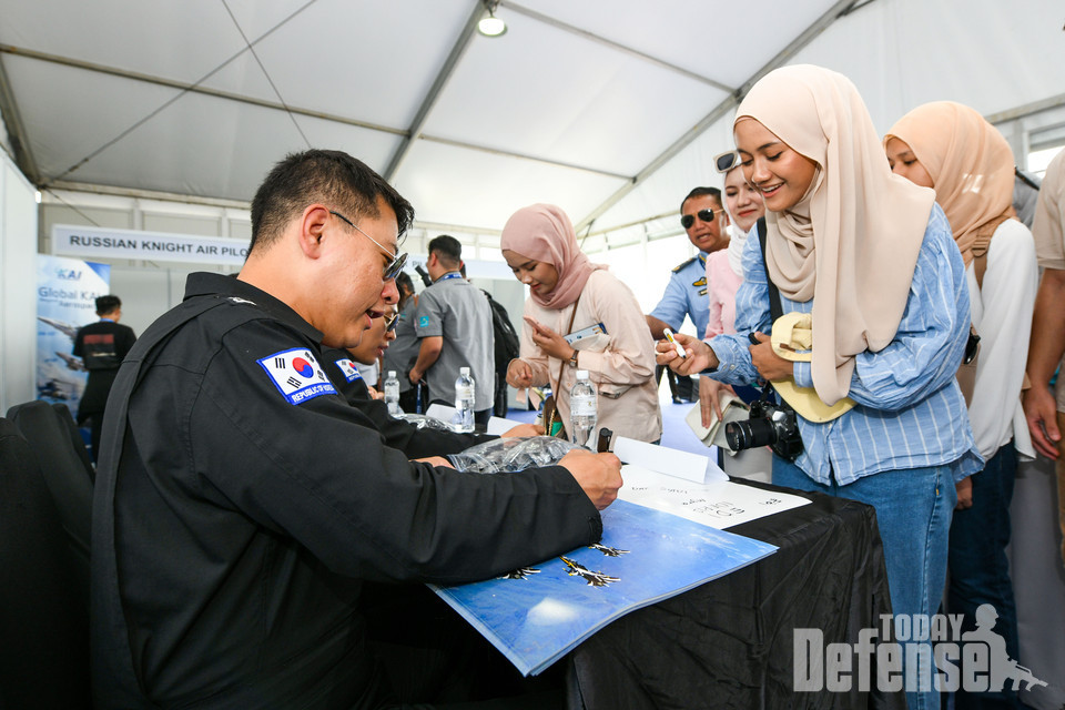말레이시아 'LIMA '23 국제에어쇼' 퍼블릭 데이가 열린 5월 26일(금)(현지시간) 공군 특수비행팀 블랙이글스(Black Eagles) 1번기 조종사 양은호 소령이 사인회를 찾은 현지 관람객과 소통하고 있다.(사진:공군)