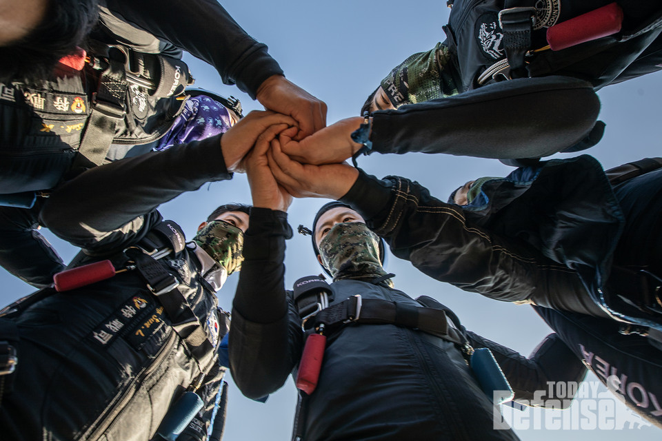 '상호활동'에 참가한 특전요원들이 강하 전 손을 맞잡고 팀워크를 다지고 있다.(사진:육군)
