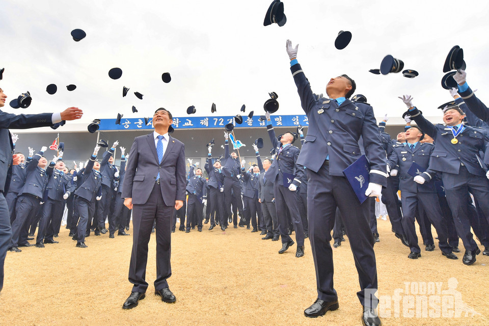 졸업생들이 신원식 국방부 장관과 함께 졸업 및 임관을 축하하며 정모를 하늘로 던지고 있다.(사진:공군)